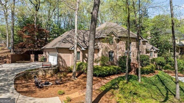 5520 Glen Errol Rd, Atlanta, GA 30327 - view of front of home featuring driveway, a garage, and stucco siding