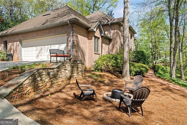 5520 Glen Errol Rd, Atlanta, GA 30327 - view of side of home with brick siding, an attached garage, concrete driveway, and a shingled roof