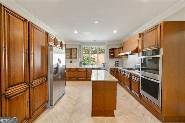 5520 Glen Errol Rd, Atlanta, GA 30327 - kitchen with stainless steel appliances, brown cabinets, crown molding, recessed lighting, and decorative backsplash