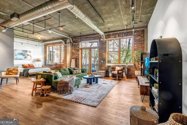 living area with wood finished floors and brick wall