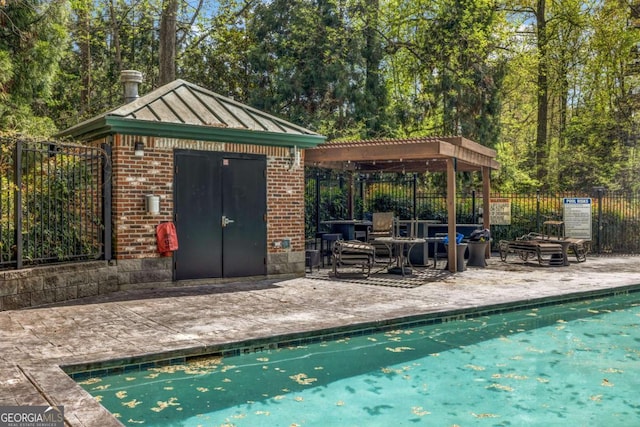 pool featuring an outbuilding, fence, a patio, and a pergola