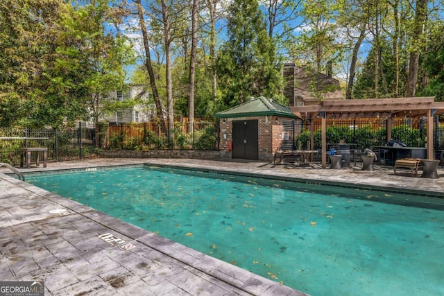 view of pool with a fenced in pool, a patio area, fence, and an outbuilding
