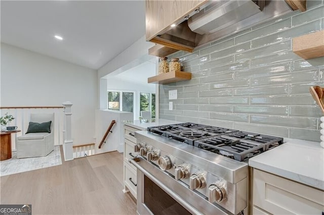 808 Sherwood Rd, Gainesville, GA 30501 - kitchen featuring stainless steel range, light countertops, light wood finished floors, decorative backsplash, and white cabinets