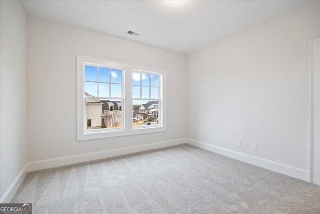 carpeted empty room featuring visible vents and baseboards