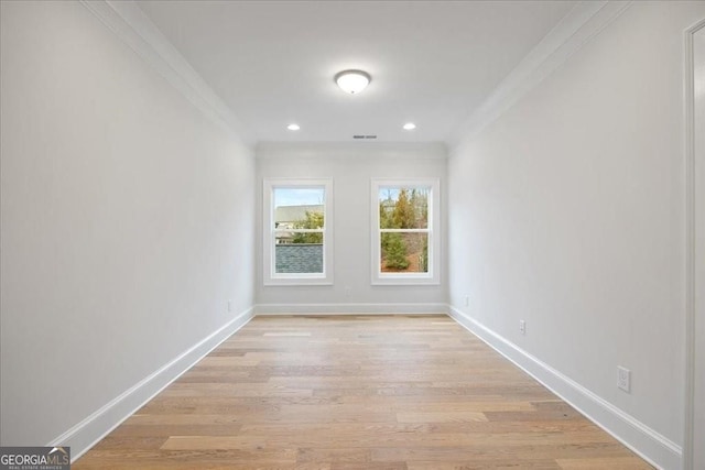 empty room with crown molding, baseboards, recessed lighting, and light wood-style floors