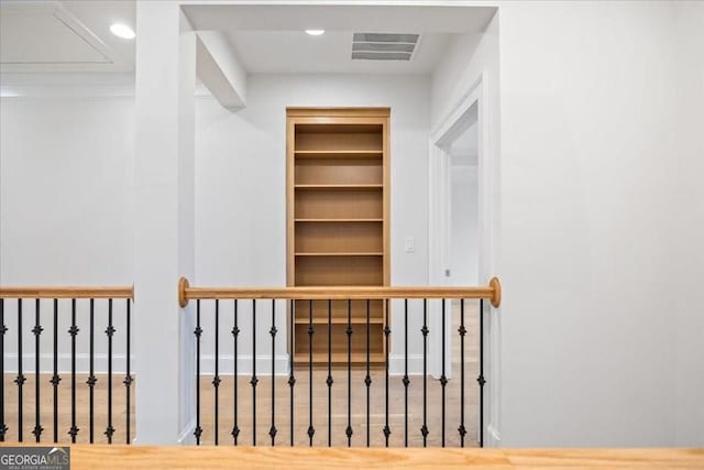 hallway with recessed lighting, visible vents, and built in features