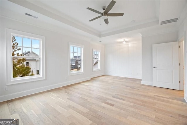 spare room featuring visible vents, a tray ceiling, and a healthy amount of sunlight