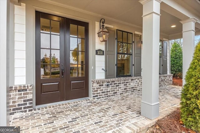 doorway to property featuring brick siding and french doors