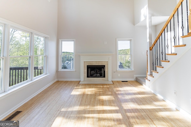 288 Pine Way, Dallas, GA 30157 - unfurnished living room with a high ceiling, wood finished floors, visible vents, and a healthy amount of sunlight