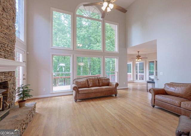 516 Turner Rd, Concord, GA 30206 - living room featuring ceiling fan, a high ceiling, light wood-style floors, and a fireplace