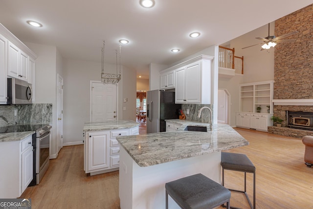516 Turner Rd, Concord, GA 30206 - kitchen with stainless steel appliances, a sink, a center island, light wood-style floors, and decorative backsplash