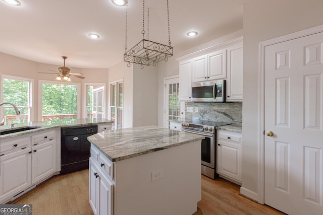 516 Turner Rd, Concord, GA 30206 - kitchen with appliances with stainless steel finishes, a sink, a kitchen island, backsplash, and light wood-style flooring