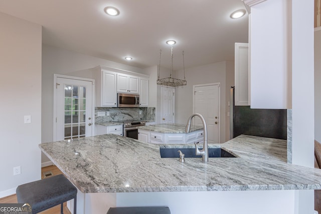 516 Turner Rd, Concord, GA 30206 - kitchen with stainless steel appliances, decorative backsplash, white cabinets, light stone countertops, and recessed lighting