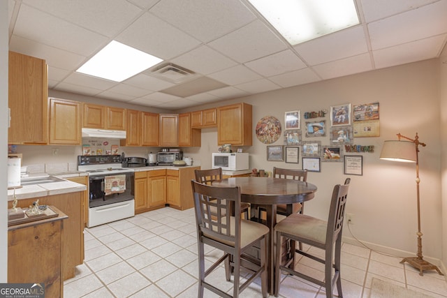 516 Turner Rd, Concord, GA 30206 - kitchen with white appliances, light tile patterned floors, under cabinet range hood, a drop ceiling, and tile countertops