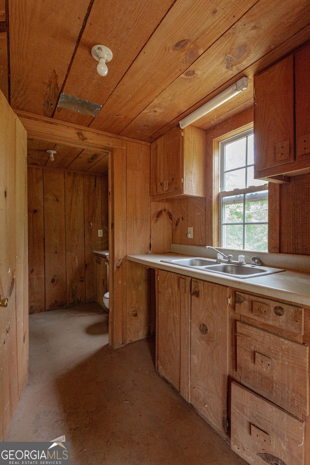 516 Turner Rd, Concord, GA 30206 - kitchen with a sink, wood ceiling, brown cabinets, wooden walls, and light countertops