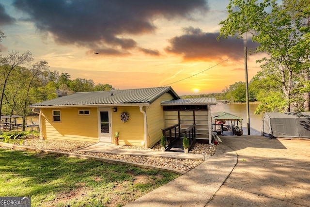 480 Friar Tuck Cir, Covington, GA 30014 - back of house at dusk featuring metal roof and driveway