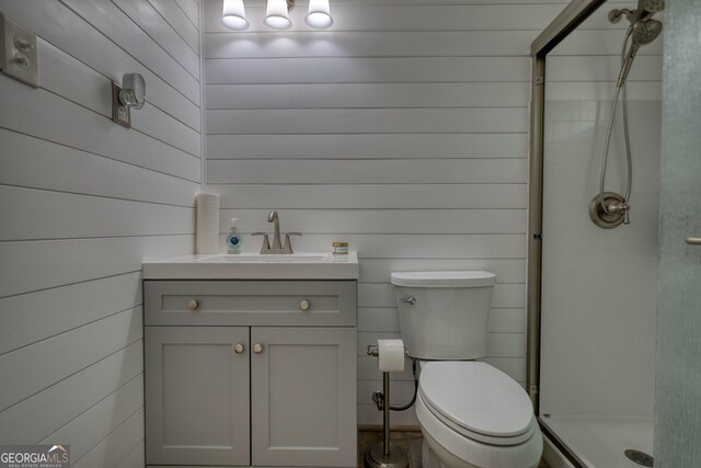 480 Friar Tuck Cir, Covington, GA 30014 - bathroom featuring wood walls, toilet, a stall shower, and vanity