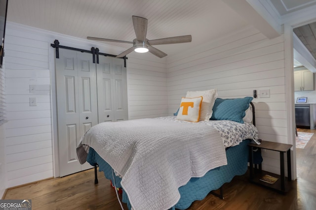 480 Friar Tuck Cir, Covington, GA 30014 - bedroom featuring wood walls, a barn door, crown molding, and wood finished floors