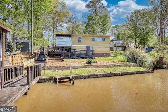 480 Friar Tuck Cir, Covington, GA 30014 - back of house with stairway, crawl space, and a deck with water view