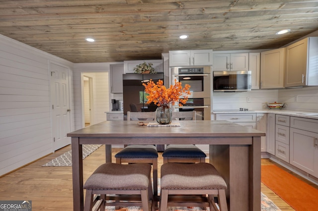 480 Friar Tuck Cir, Covington, GA 30014 - kitchen featuring a breakfast bar, light wood-type flooring, wood ceiling, and appliances with stainless steel finishes