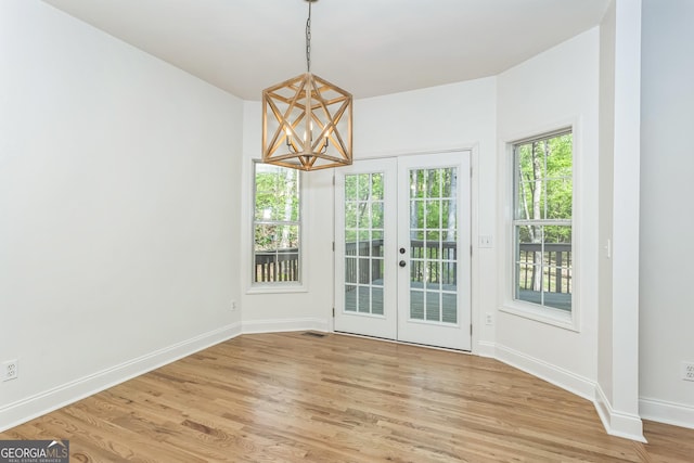 8660 Anchor On Lanier Ct, Gainesville, GA 30506 - unfurnished dining area with french doors, a chandelier, light wood-style floors, and baseboards
