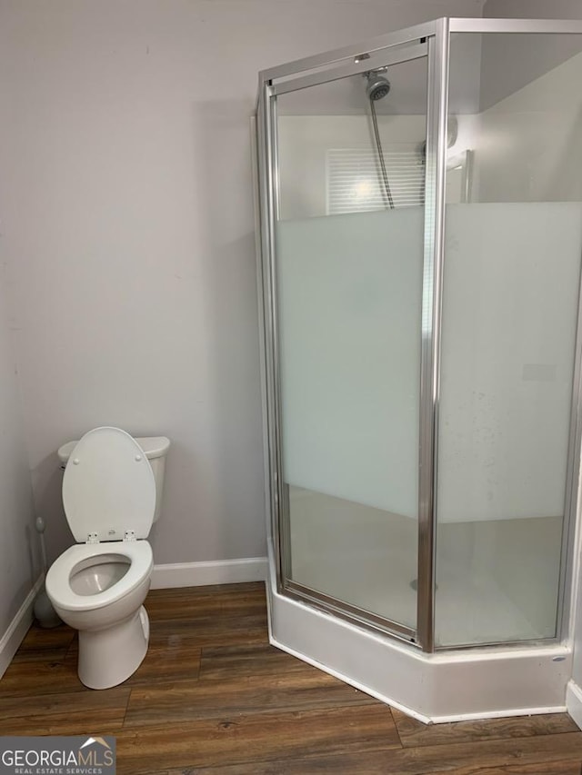 2467 Shady Grove Rd, Carrollton, GA 30116 - full bathroom with baseboards, a shower stall, wood finished floors, and toilet