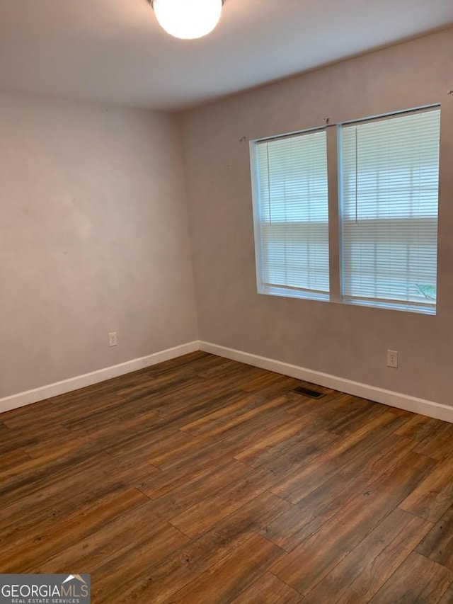 2467 Shady Grove Rd, Carrollton, GA 30116 - unfurnished room with baseboards, dark wood-style flooring, and healthy amount of natural light