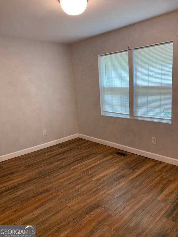 2467 Shady Grove Rd, Carrollton, GA 30116 - spare room with baseboards and dark wood-type flooring
