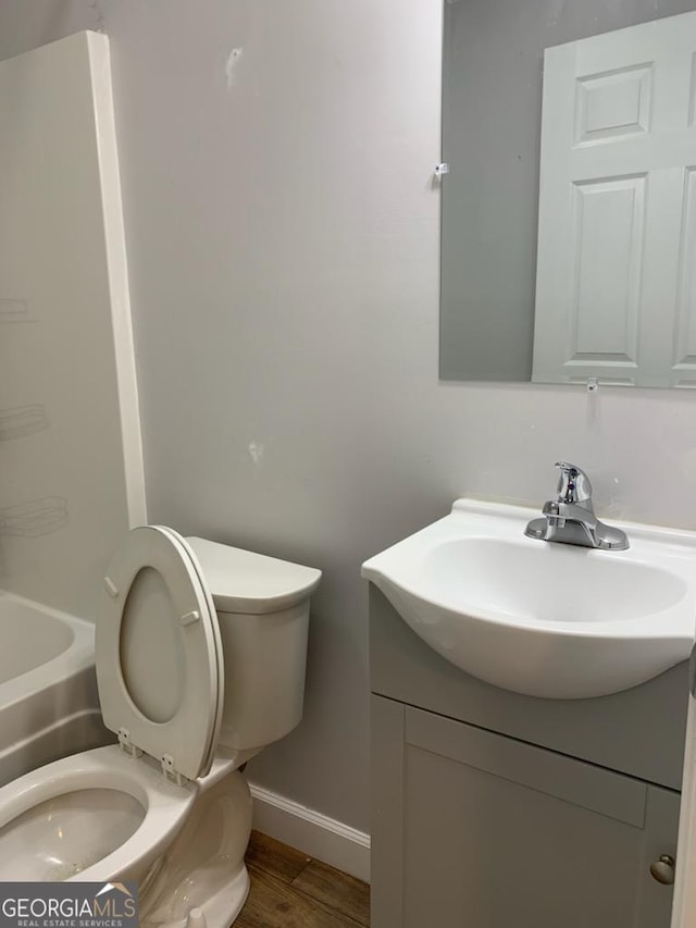 2467 Shady Grove Rd, Carrollton, GA 30116 - full bath with vanity, toilet, baseboards, and wood finished floors