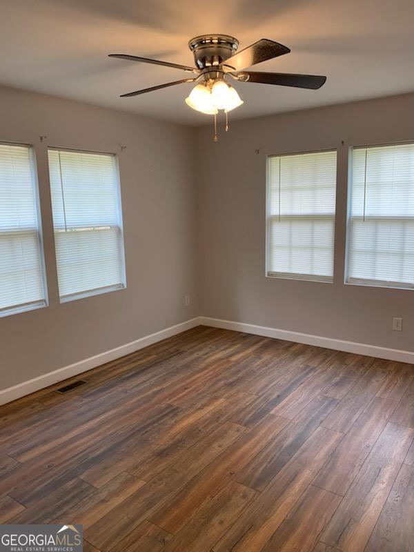 2467 Shady Grove Rd, Carrollton, GA 30116 - spare room with dark wood finished floors, ceiling fan, and baseboards