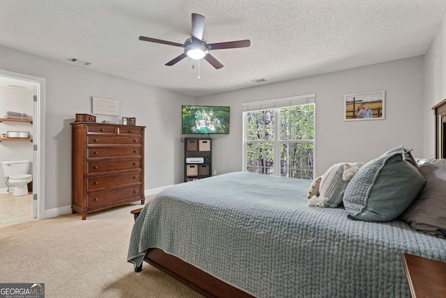 bedroom featuring visible vents, a textured ceiling, light colored carpet, and ceiling fan