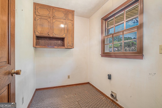 laundry room featuring baseboards, electric dryer hookup, cabinet space, a textured ceiling, and carpet flooring