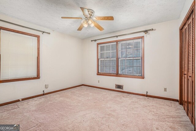 unfurnished bedroom with carpet, a closet, baseboards, and visible vents