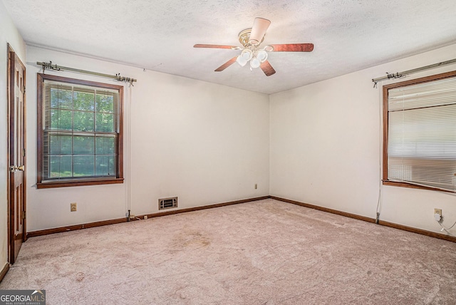 unfurnished room with ceiling fan, carpet floors, and a textured ceiling
