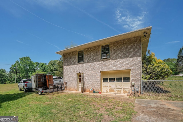 rear view of property with fence, a lawn, and brick siding