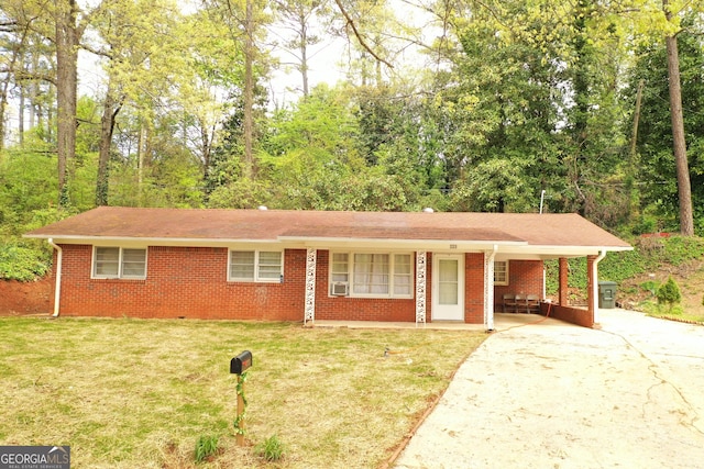 ranch-style house featuring a carport, driveway, cooling unit, a front yard, and brick siding