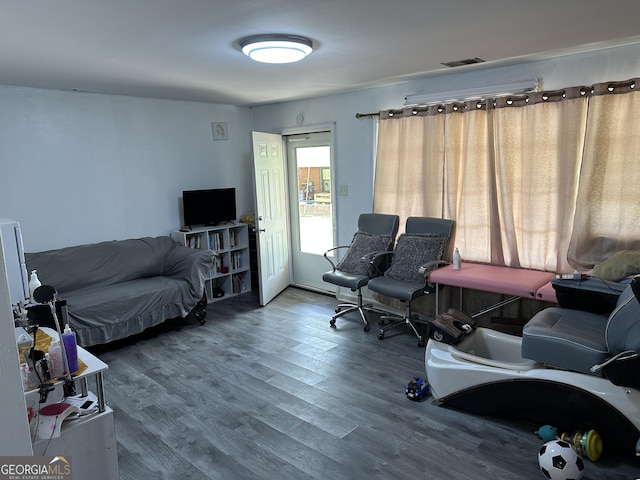 living area featuring visible vents and wood finished floors