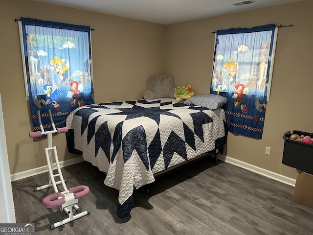 bedroom featuring visible vents, baseboards, and wood finished floors