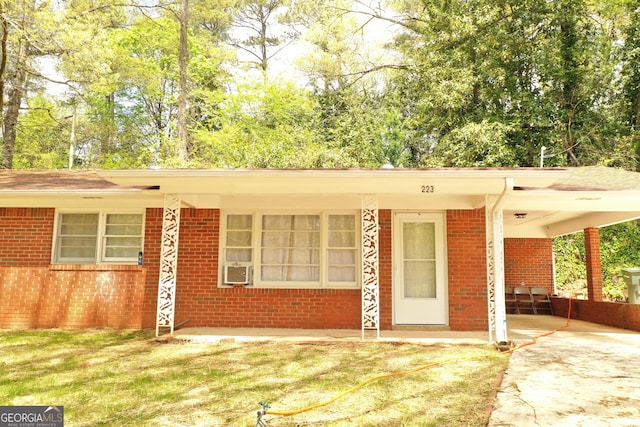 ranch-style home with an attached carport, brick siding, and driveway