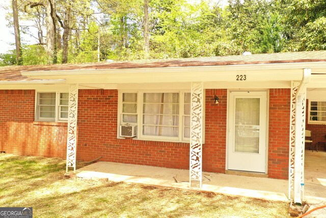 entrance to property with brick siding and cooling unit