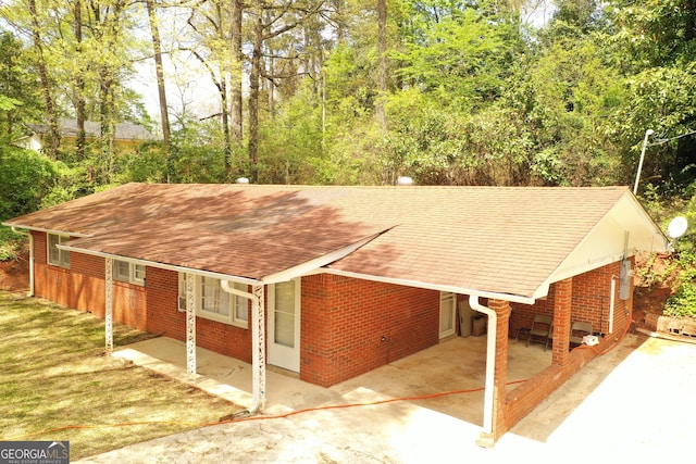 view of front of house with roof with shingles and brick siding