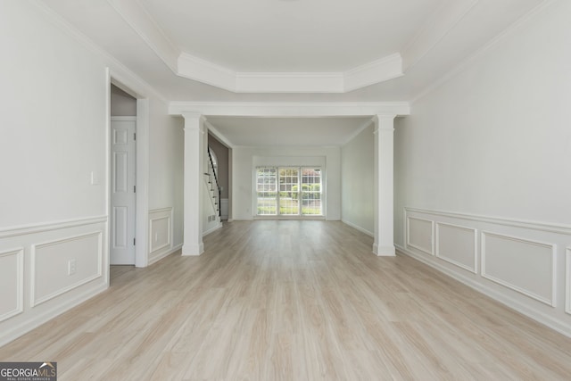 2635 Stonehill Dr, Cumming, GA 30041 - unfurnished living room with a decorative wall, crown molding, ornate columns, stairway, and light wood finished floors