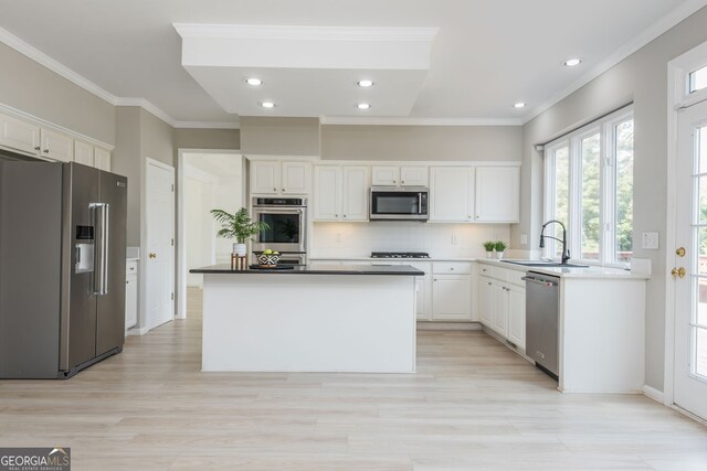 2635 Stonehill Dr, Cumming, GA 30041 - kitchen featuring ornamental molding, backsplash, white cabinets, stainless steel appliances, and a sink