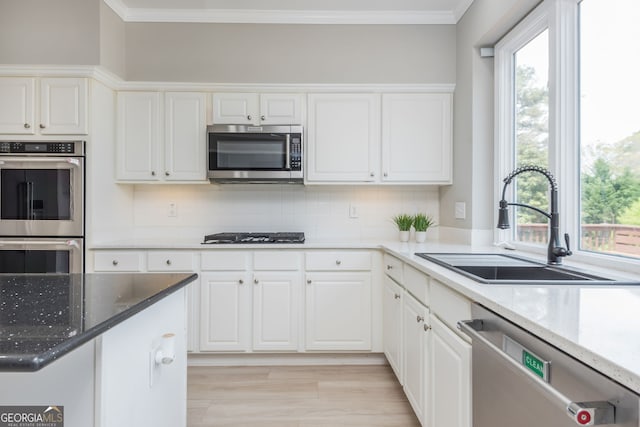 2635 Stonehill Dr, Cumming, GA 30041 - kitchen with crown molding, tasteful backsplash, white cabinets, a sink, and stainless steel appliances