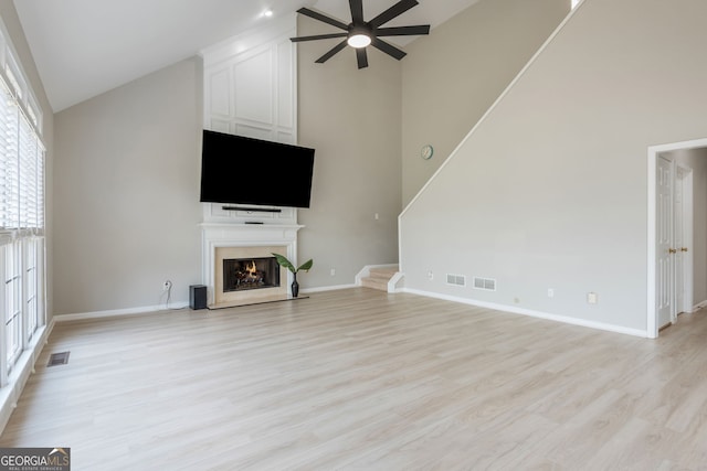 2635 Stonehill Dr, Cumming, GA 30041 - unfurnished living room featuring a large fireplace, light wood-style flooring, a ceiling fan, visible vents, and high vaulted ceiling