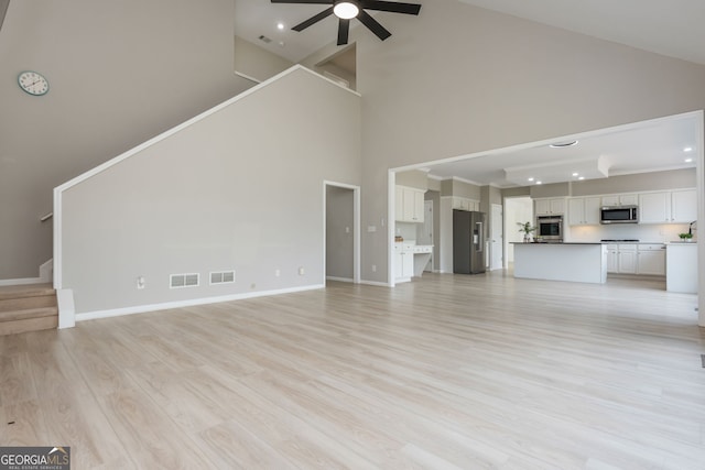 2635 Stonehill Dr, Cumming, GA 30041 - unfurnished living room featuring visible vents, a ceiling fan, recessed lighting, stairs, and high vaulted ceiling