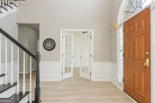 2635 Stonehill Dr, Cumming, GA 30041 - foyer entrance featuring french doors, a wainscoted wall, stairway, and light wood-style floors