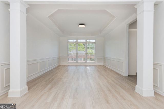2635 Stonehill Dr, Cumming, GA 30041 - unfurnished living room with a raised ceiling, a decorative wall, decorative columns, and light wood finished floors