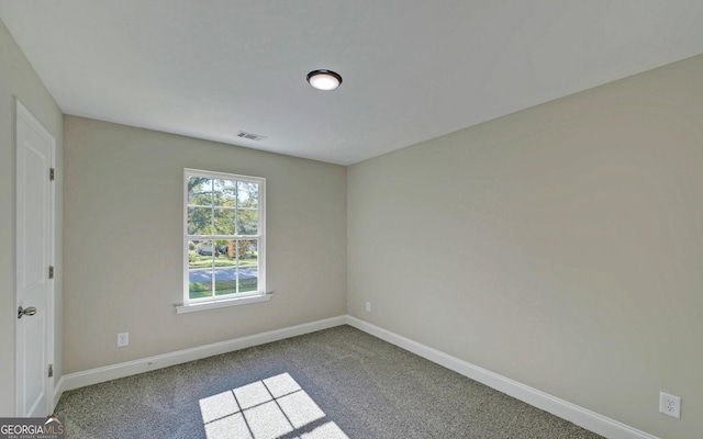 carpeted empty room featuring baseboards and visible vents