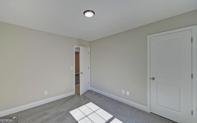 unfurnished bedroom with baseboards and carpet flooring